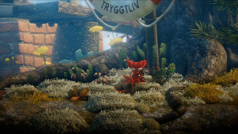 Unravel: Yarny hält einen Knopf